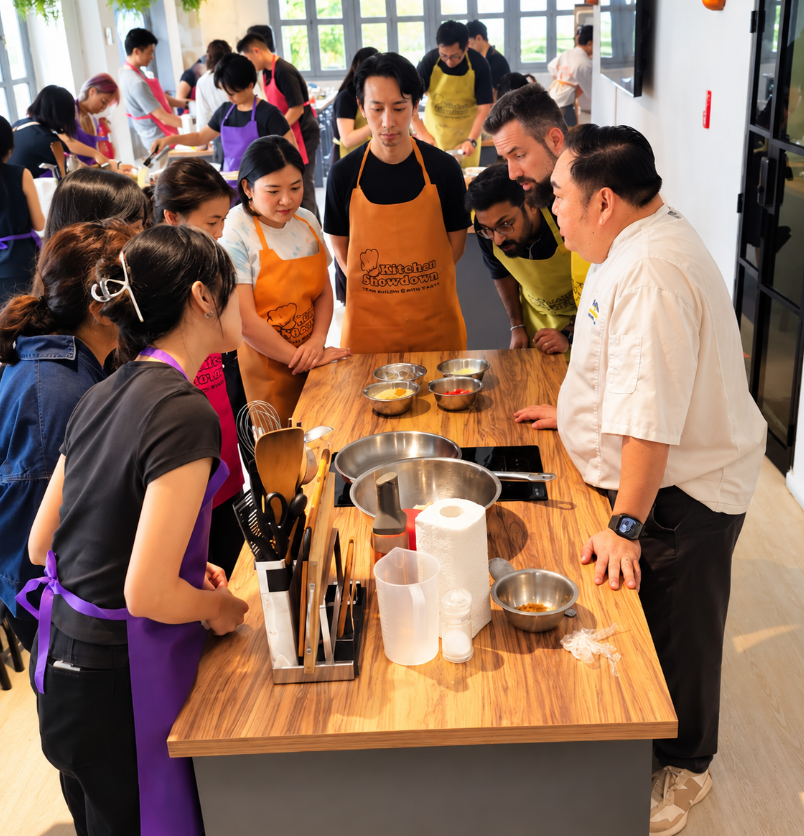 Large corporate group posing with a trophy and medals after a Kitchen Showdown cooking competition